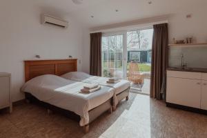 东卡佩勒昂斯堡特酒店的一间卧室设有一张床和一个大窗户
