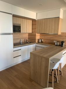 多维尔Horizon Bleu的厨房配有白色橱柜和木制台面