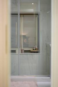 爱琴娜岛Naias Aegina, Sea-front apartment 95 sqm的带淋浴的浴室和玻璃门