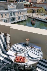 阿威罗1877 Estrela Palace的阳台上的一张桌子上放着两盘食物