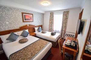 伦敦彭布里奇皇宫酒店的酒店客房设有两张床和电视。