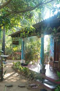 亭可马里Akki's Hostel的花园中带蓝色柱子的凉亭