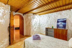 圣布里希达La Cueva de Tito-Casa Cueva en plena naturaleza的一间卧室设有一张床和木制天花板
