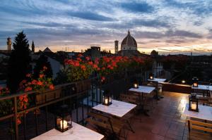 佛罗伦萨Hotel Cardinal of Florence - recommended for ages 25 to 55的阳台的庭院配有桌子和鲜花