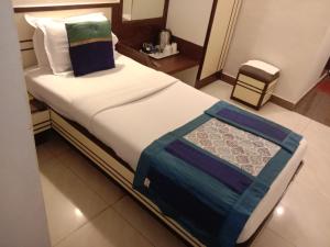 孟买Strand Hotel, Colaba的一张位于酒店客房的床铺,床上有毯子