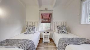 绍斯布鲁姆San Lameer Villa 3002 by Top Destinations Rentals的带窗户的客房内设有两张单人床。