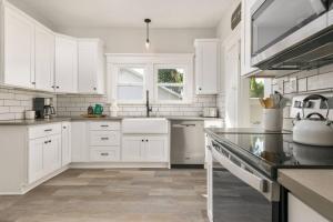 格雷舍姆Powell Place的白色的厨房配有白色橱柜和水槽