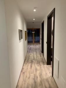 巴塞尔加·迪·皮纳Appartamenti e B&B Casa Ester的走廊设有白色墙壁和木地板