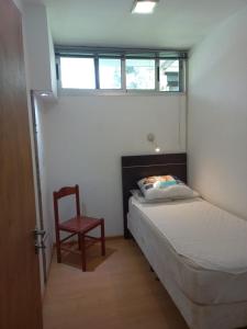 波萨达斯Parana Riverside Guest House - Posadas的卧室配有床、椅子和窗户。