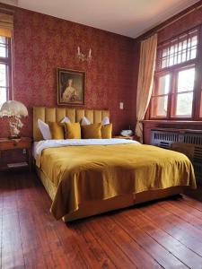 ZachełmieRezydencja Lawendowe Wzgórze的一间卧室配有一张大床和金色床罩