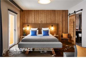 谷雪维尔Ecrin Blanc Resort Courchevel - Aquapark的一间卧室配有一张带蓝色枕头的大床