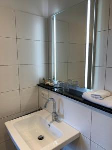 诺德奈Georg Rass Gästehaus的一间带水槽和大镜子的浴室