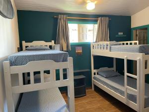 卡姆布库Bada Hostel & Kite School的蓝色墙壁的客房内设有两张双层床。