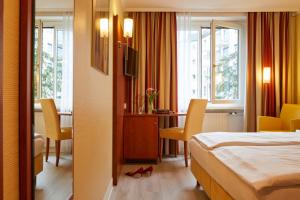 慕尼黑协和酒店的酒店客房带一张床、一张桌子和椅子