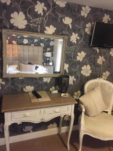 瓦伊河畔罗斯Castle Lodge Wilton的一间卧室配有书桌、镜子和床