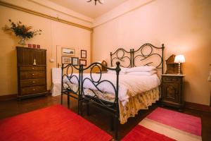 费尔莫罗姆宫阿达米旅馆的一间卧室配有一张大床和红色地毯。