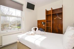 伦敦切尔西宾客别墅酒店的卧室配有白色的床和窗户。