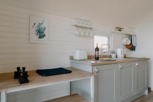 StrathyStrathy Bay Pods的厨房配有白色橱柜和台面