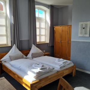 TimmelHotel Restaurant Kastanjehoff的一间卧室配有一张带白色床单的床和一扇窗户。