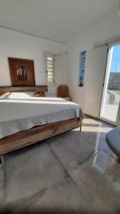 米克诺斯城Arion suites Mykonos的一间卧室设有一张大床和一个大窗户