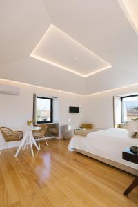 阿鲁卡Casa Vieira Lobo的白色卧室配有床和桌子