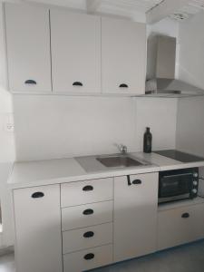 卡米拉日To Spiti Tou Papa Sto Vouno的白色的厨房配有水槽和微波炉