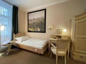 布拉格色温兹多红椅酒店的卧室配有1张床、1张桌子和1把椅子
