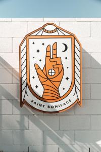 印地欧Saint Boniface Hotel的砖墙上的标志,手上有和平标志