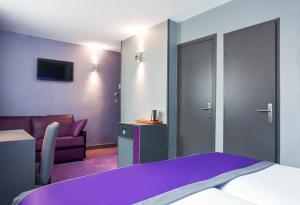 里昂里昂佩拉什萨伏依酒店的酒店客房配有紫色的床和沙发。