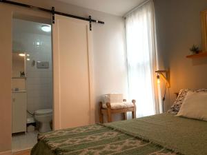 圣萨尔瓦多德朱Casa Olavarria的一间卧室配有一张床,浴室设有卫生间