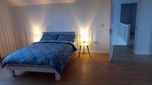 GeevaghGeevagh Holiday Home的一间卧室配有一张带蓝色被子和两个灯的床。