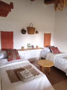 蒂尔卡拉Casa Inkill Huasi的一间设有两张床和一张桌子的房间