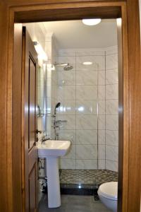 比托拉Chola Guest House的浴室配有盥洗盆、淋浴和卫生间