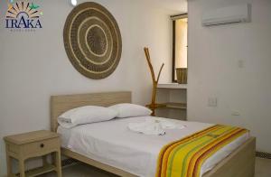 辛塞莱霍Hotel Iraka Zenu的卧室配有一张床,墙上配有风扇