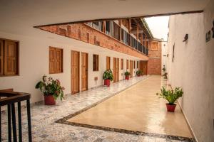 杰里科Hotel Santa Laura的建筑里空荡荡的走廊,有盆栽植物