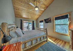 埃利杰Amazing Creek View Cabin w/ Hot Tub, Firepit & Pool Table的一间卧室配有一张床和吊扇