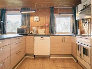 Sindrup6 person holiday home in Hurup Thy的厨房配有木制橱柜和墙上的时钟