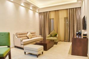 迪拜Carlton Dubai Creek Hotel的客厅配有椅子、沙发和桌子