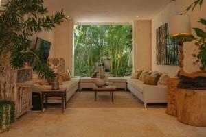 蓬塔卡纳Luxurious fully-staffed villa with amazing view in exclusive golf & beach resort的带沙发和大窗户的客厅