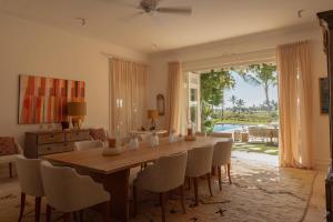 蓬塔卡纳Luxurious fully-staffed villa with amazing view in exclusive golf & beach resort的一间带木桌和椅子的用餐室
