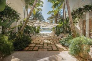 蓬塔卡纳Unique lake-front 10-bedroom mansion in most luxurious resort of the caribbean的石头人行道,带遮阳伞和游泳池