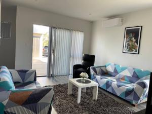 奥克兰4 bedroom home fully furnished in Papakura, Auckland的客厅配有沙发和桌子