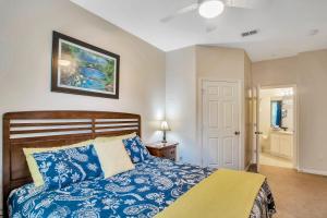 奥兰多Magical Adventure Condo w Waterpark near Disney No Resort Fees的卧室配有蓝色和白色的床和一扇门