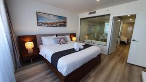 黄金海岸Luxury Oceanview Apartment on Lvl 24的一间带大床的卧室和一间浴室