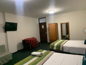特鲁希略Hotel Las Mercedes的酒店客房设有两张床和电视。