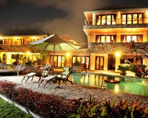 乌鲁瓦图The Rishi Villa Balangan的一座房子,设有游泳池、椅子和遮阳伞