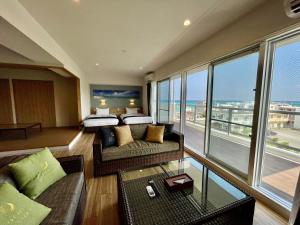 恩纳Coral Palace Onna by Sunset Avenue的酒店客房设有一张床,享有海景。