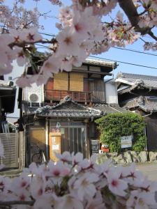 琴平町Guesthouse Kotohira的前面有粉红色花的建筑