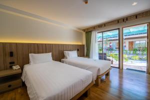 查汶Baan Samui Resort - SHA Extra Plus的一间卧室设有两张床和大窗户