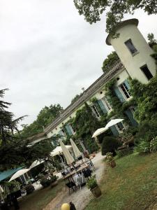 卡斯特尔杜门德拉薇巴里耶住宿加早餐旅馆的一座大建筑前面设有桌子和遮阳伞